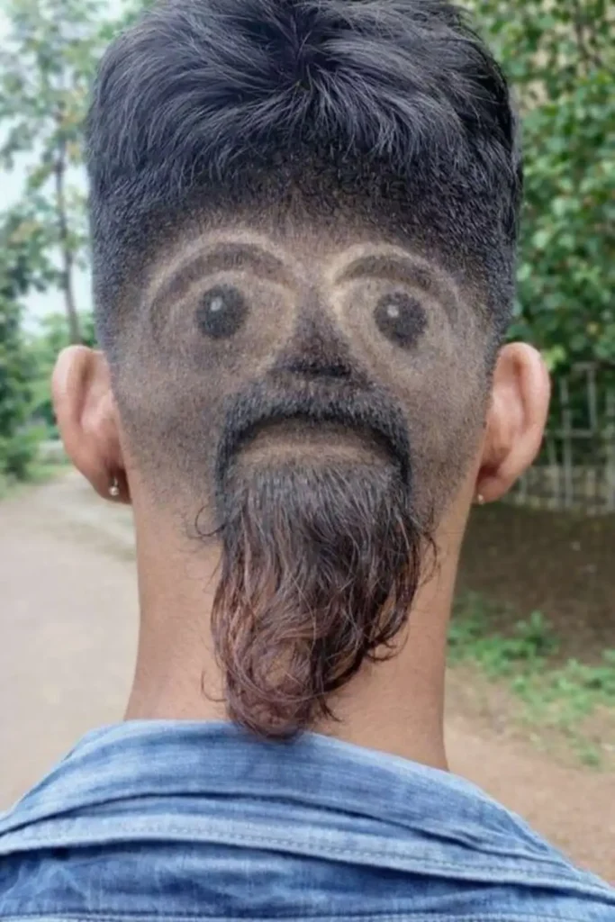 Back of head haircut design showing a realistic face carved into faded hair, with detailed eyes, eyebrows, mustache, and beard created using hair art
