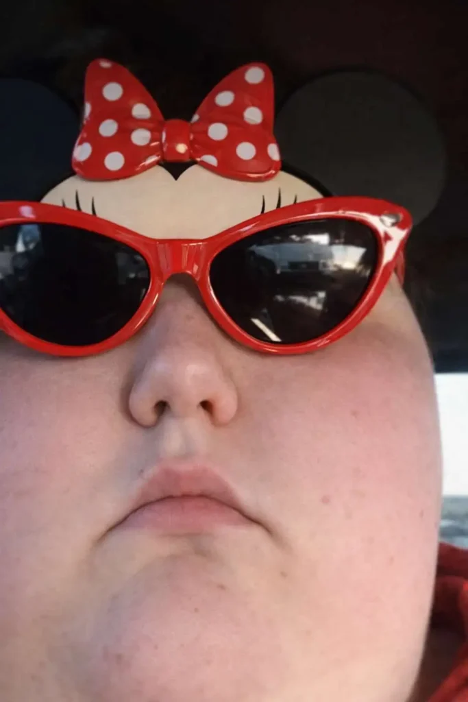 Goofy ahh meme close-up wearing red bow sunglasses with serious face