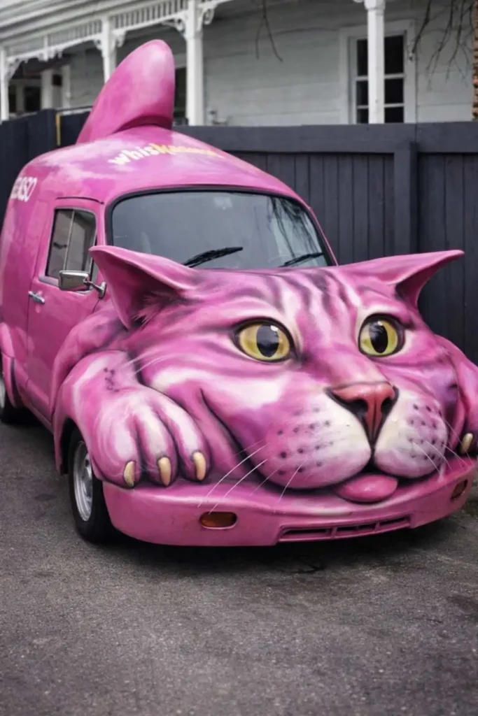 Pink cat-themed van with a giant feline face, ears, and paws sculpted into the front